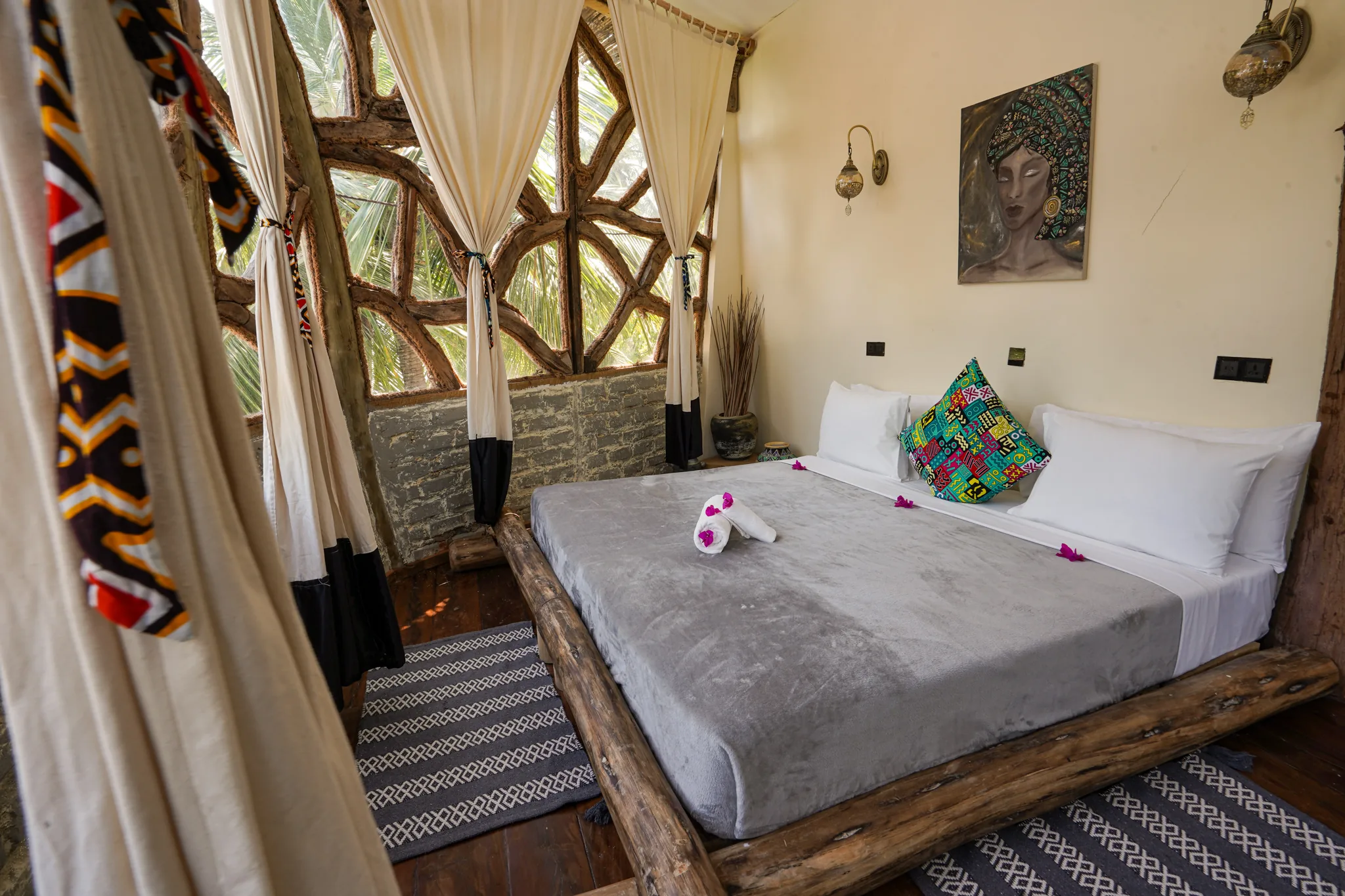 Tree house bedroom with king bed, arched window and African art