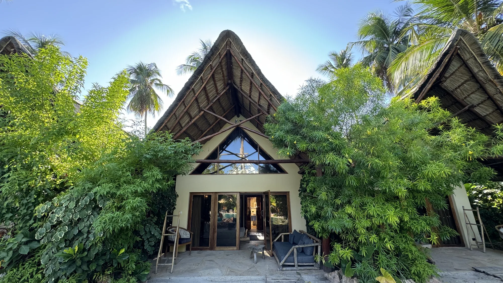 Exterior of the A-frame villa among palm trees