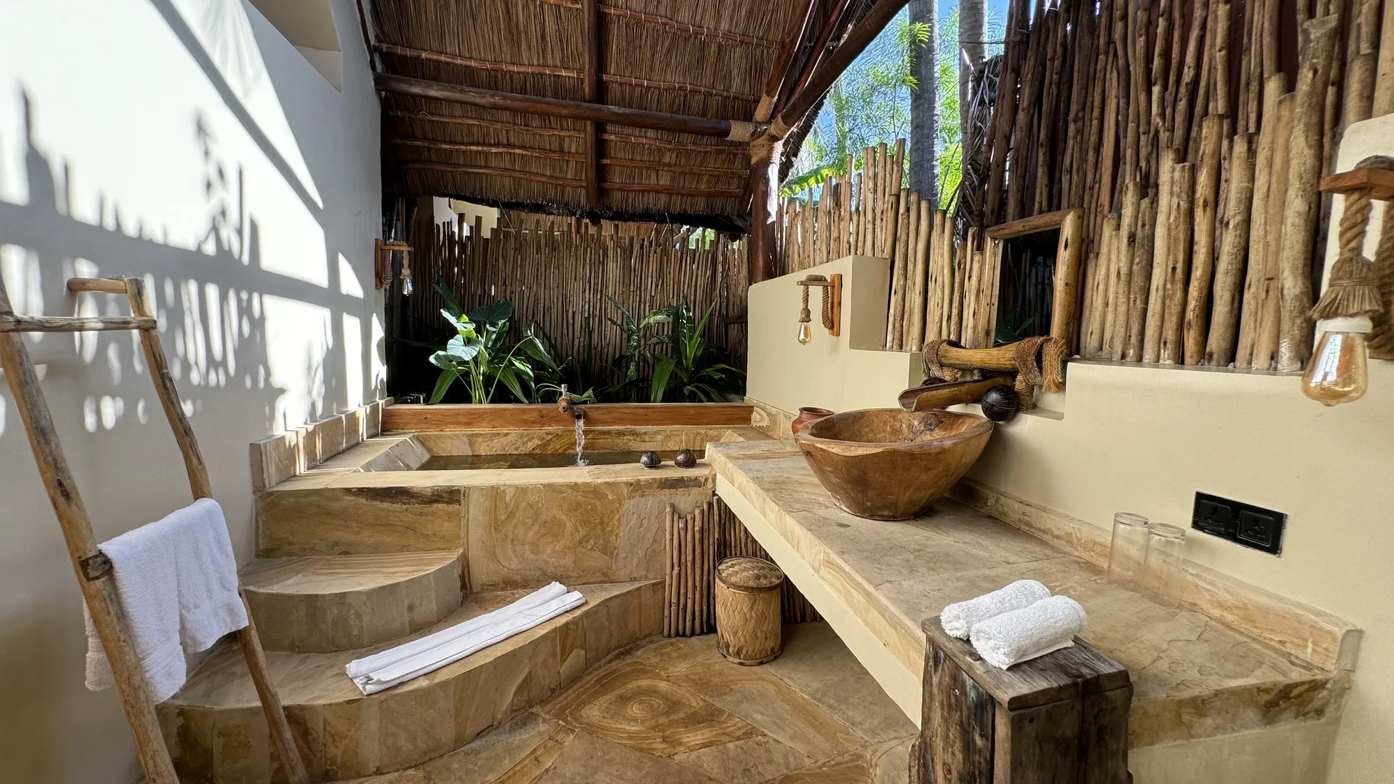 Outdoor bathroom with carved stone basin
