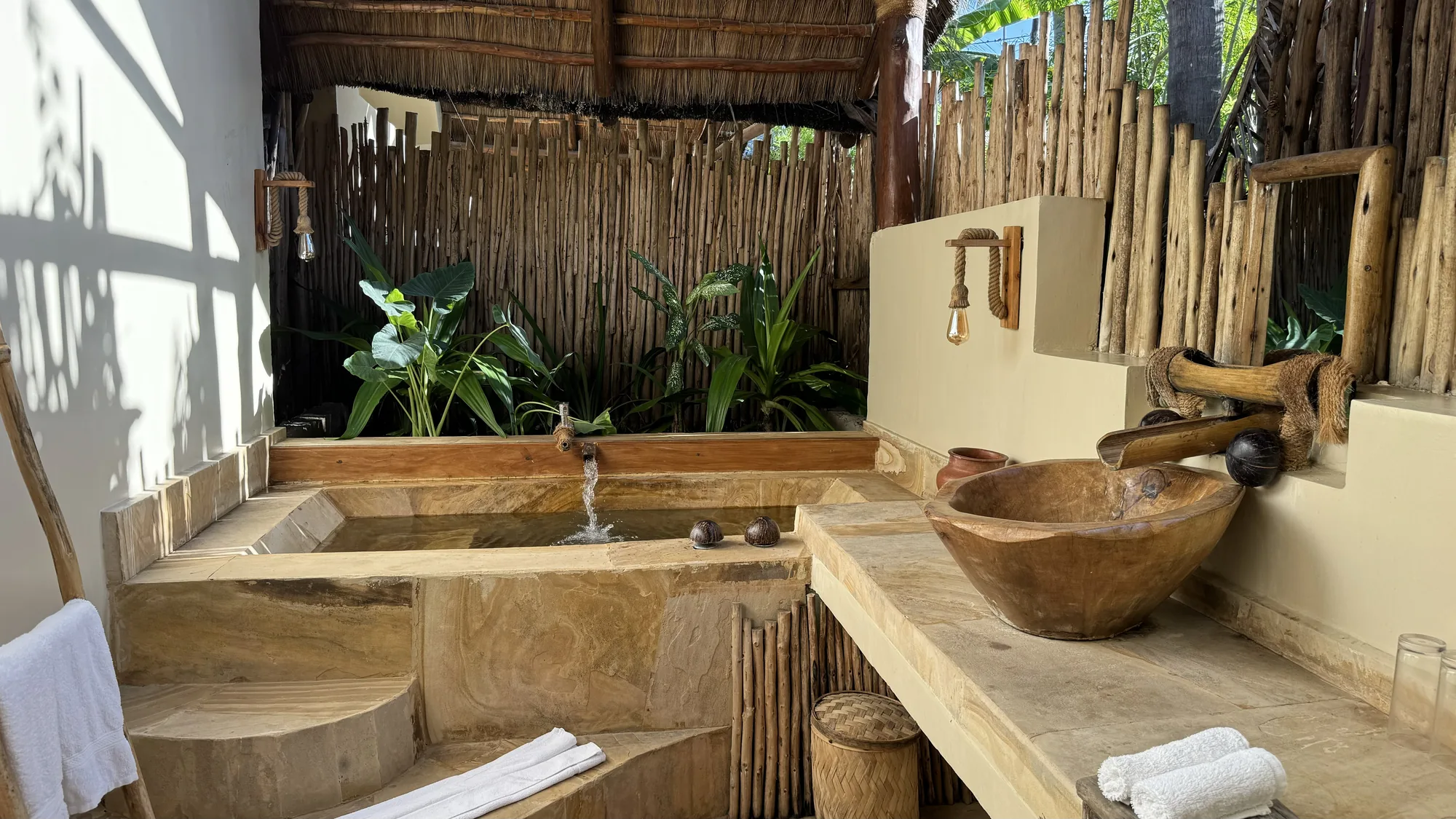Sunken stone bath among tropical plants