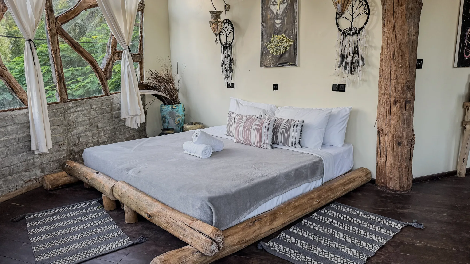 Nest tree house bedroom with African art, dreamcatcher and light through the arched window